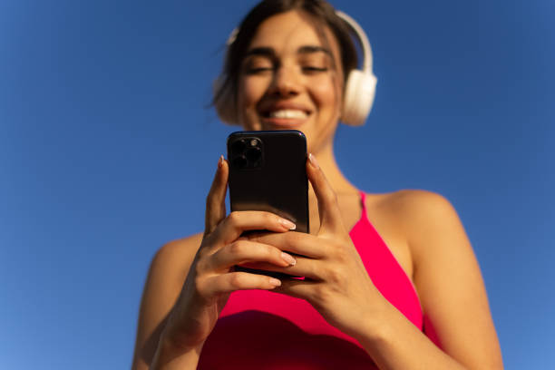 istock Happy sportswoman using a smart phone 1418152528