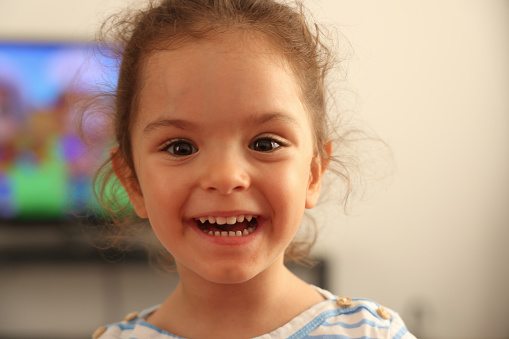 Little girl portrait with toothy smile.