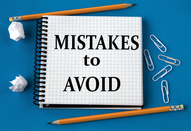 istock MISTAKES TO AVOID - words in a white notebook on a blue background with pencils, paper clips 1418156727