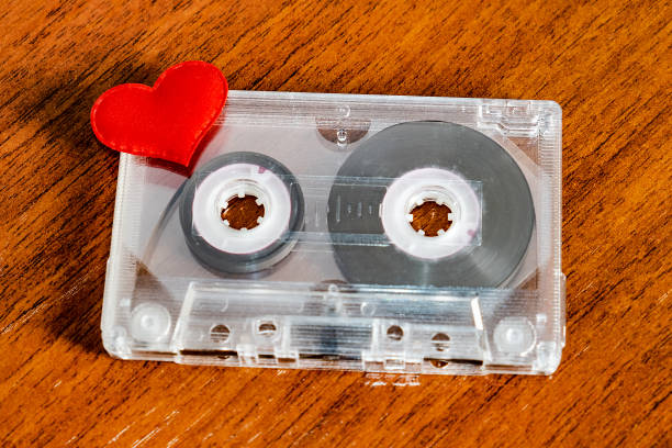 Audio Cassette with a Heart Audio Tape Cassette with a Red Heart on the Wooden Table closeup mix tape heart stock pictures, royalty-free photos & images