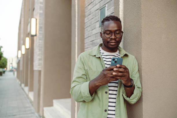 istock Young man texting and using smart phone on the street 1418160384