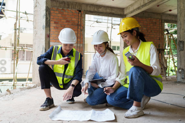 istock Structural engineer and architect discussing and working with blueprints at the outdoors construction site 1418160716