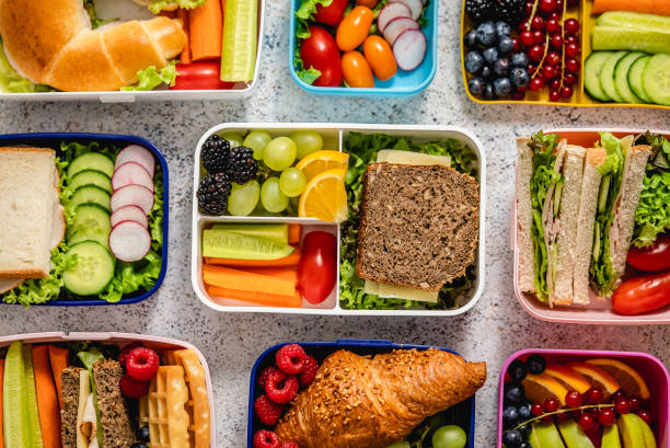 aufnahme von schullunchboxen mit verschiedenen gesunden, nahrhaften mahlzeiten auf steinhintergrund - bento box lunch healthy lifestyle stock-fotos und bilder