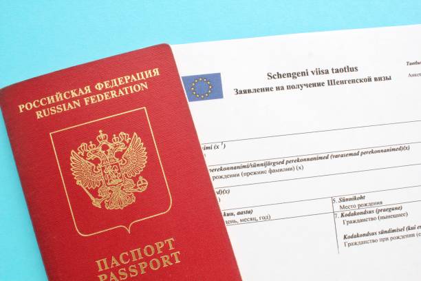 istock Schengen visa application form in Russian and Estonian language and passport on blue background 1418163973