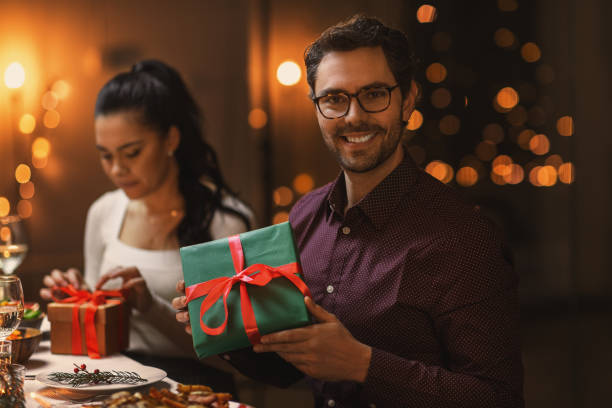 istock happy smiling man with christmas gift at home 1418166929