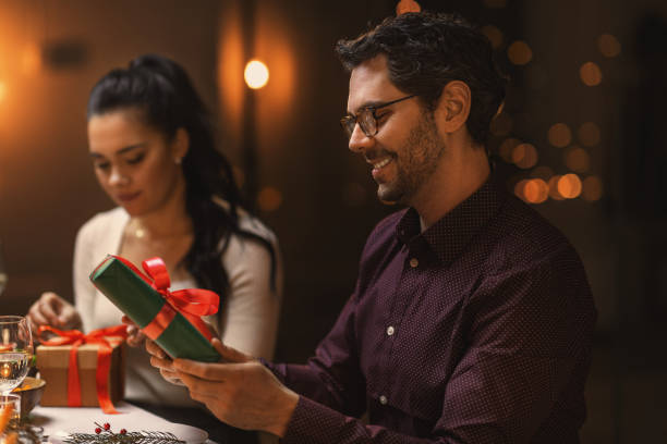 istock happy smiling man with christmas gift at home 1418167307