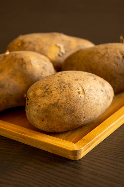 istock close up raw potatoes on wooden table at home 1418167744