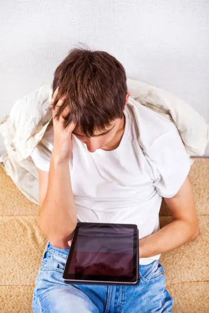 Sad Young Man with Tablet Computer at the Home