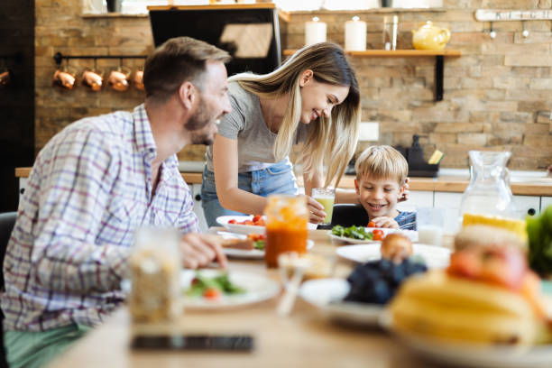 istock Young mother giving fresh celery  juice to her son during breakfast time 1418169372