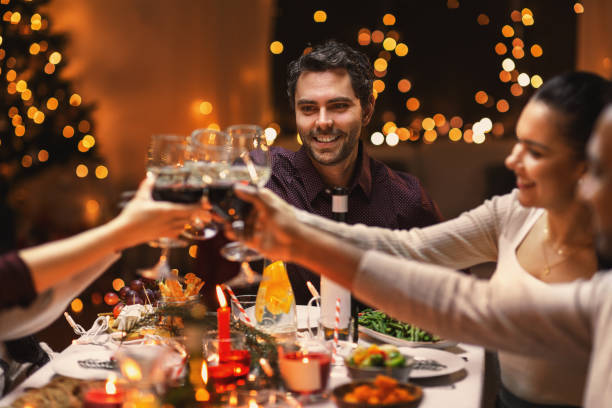 istock happy friends drinking wine at christmas party 1418169403