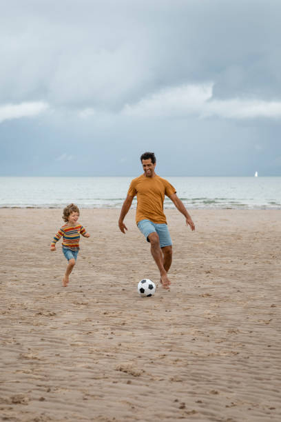 istock Playing Football by the Sea 1418169903