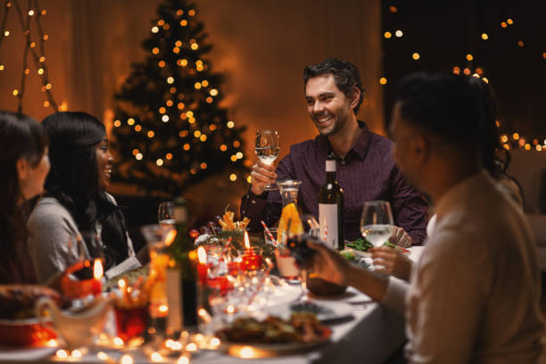 istock happy friends drinking wine at christmas party 1418170801