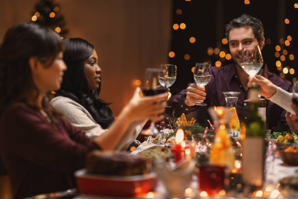 istock happy friends drinking wine at christmas party 1418171230