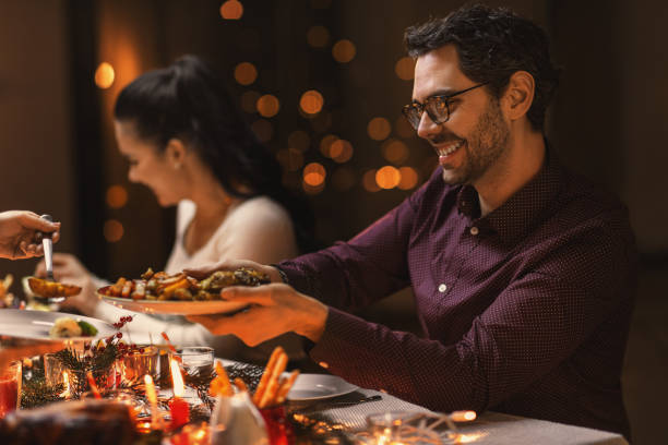 istock happy man with friends having christmas dinner 1418171380