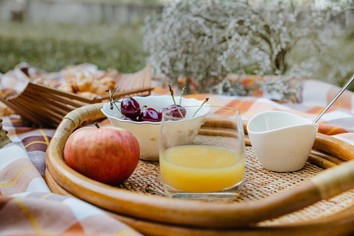 Still life from a picnic blanket with fresh fruit and pastry.