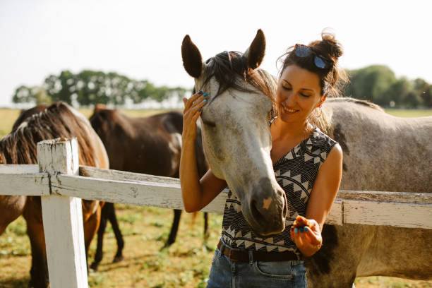 istock woman enjoying time with horses on the ranch 1418171805