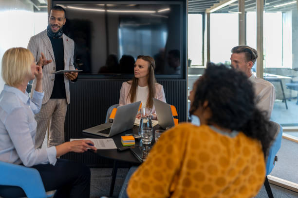 istock Colleagues discuss issues in a modern startup office and conference room. 1418171965