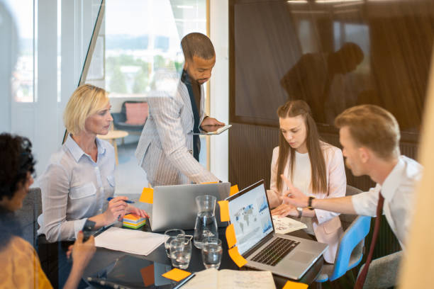 istock Colleagues discuss issues in a modern startup office and conference room. 1418171968