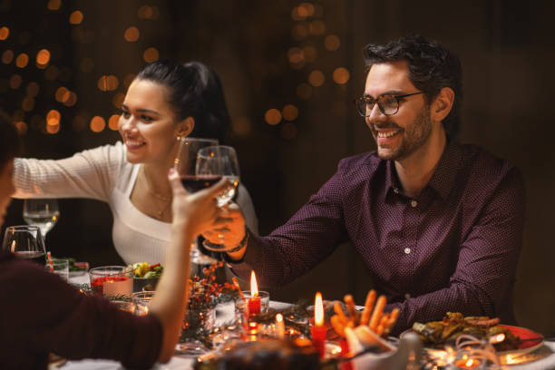 istock happy friends drinking wine at christmas party 1418172803