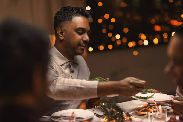 istock happy man with friends having christmas dinner 1418173155
