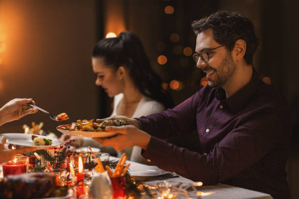 istock happy man with friends having christmas dinner 1418174691
