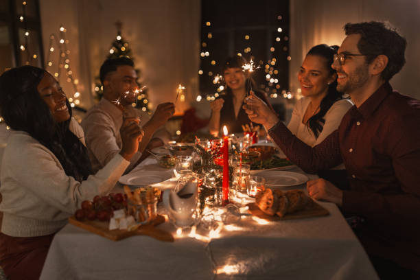 istock happy friends with sparklers at christmas dinner 1418174873