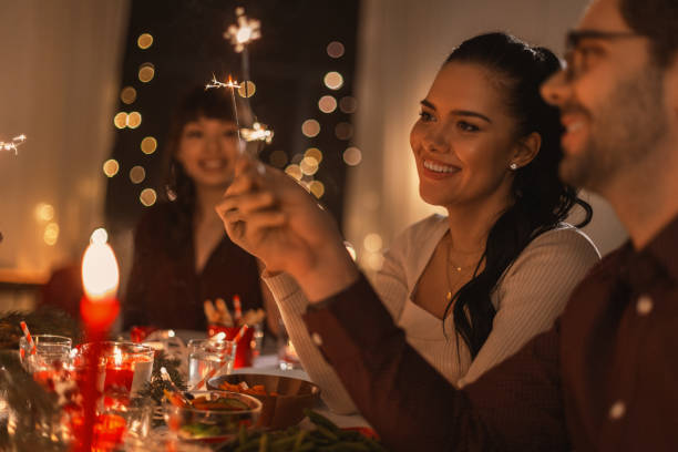 istock happy friends with sparklers at christmas dinner 1418175477