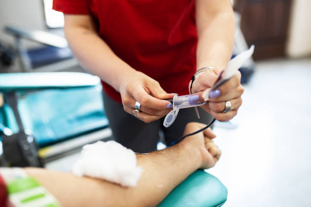 Close-up on a nurse putting an IV drip on a patient at the hospital - healthcare and medicine concepts