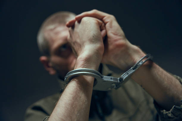 istock Close-up of hands in handcuffs on a blurred background 1418176398