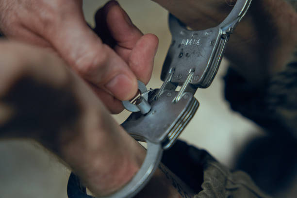 istock An officer closes handcuffs with a key on criminal's hands 1418176465