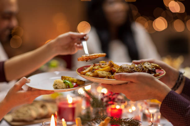 close up of people share food at christmas dinner holidays, eating and celebration concept - close up of friends having christmas dinner at home and sharing food banquet stock pictures, royalty-free photos & images