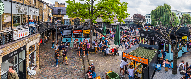 Crowds of shoppers and tourists in the courtyards of Camden Market beside the street food stalls in London, UK.