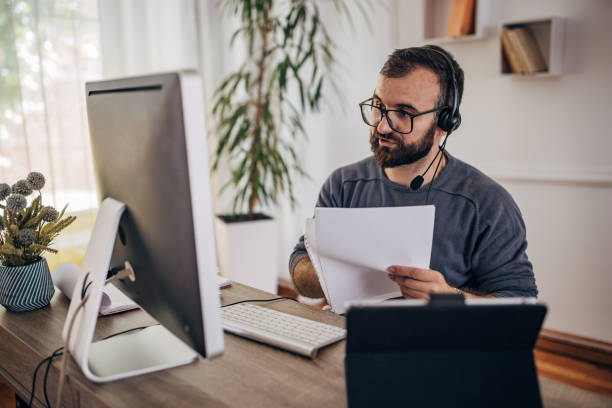 istock Man working on computer at home office and having online meeting 1418180626