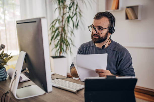 istock Man working on computer at home office and having online meeting 1418180671