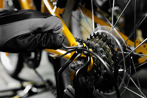 bicycle maintenance and repair. mechanic working in bike service workshop. gear closeup