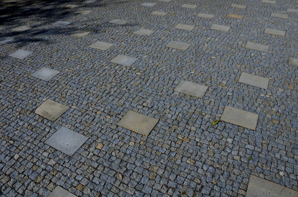 istock granite cobblestone tiles in a large area and inside cut irregularly placed cut stone slabs, stone tiles squares in a finer paving of granite mosaic cubes in an irregular dispersion contrasting size 1418181956