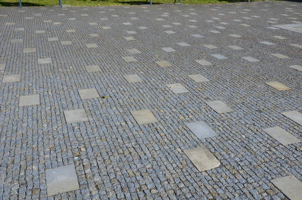 istock granite cobblestone tiles in a large area and inside cut irregularly placed cut stone slabs, stone tiles squares in a finer paving of granite mosaic cubes in an irregular dispersion contrasting size 1418181957