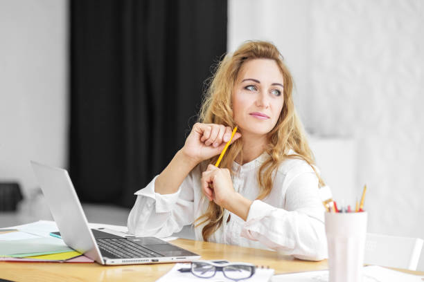 istock Beautiful woman sits at a computer and thinks. Concept for business, work, career. 1418183198