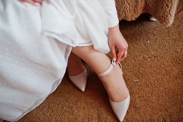istock Wedding day preparation. Bride wearing shoes. 1418185027