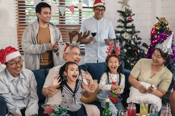 gruppo di famiglia senior e nipoti che si divertono a festeggiare la festa di natale e capodanno a casa - 25 30 years foto e immagini stock