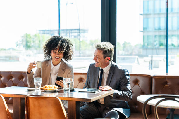 カフェでのビジネスミーティング - two people business lunch multi ethnic group meeting ストックフォトと画像