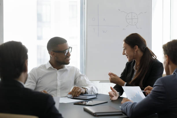 istock Happy young diverse colleagues discussing working issues in office. 1418192879