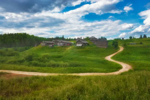 Beautiful village on a hill with wooden houses in Arkhangelsk region in summer in Russia.