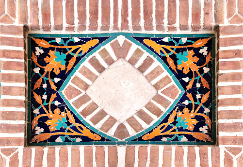 Detail of old mosaic wall with traditional georgian floral pattern of yellow and blue colors in brick frame. Mock up template. Copy space for text