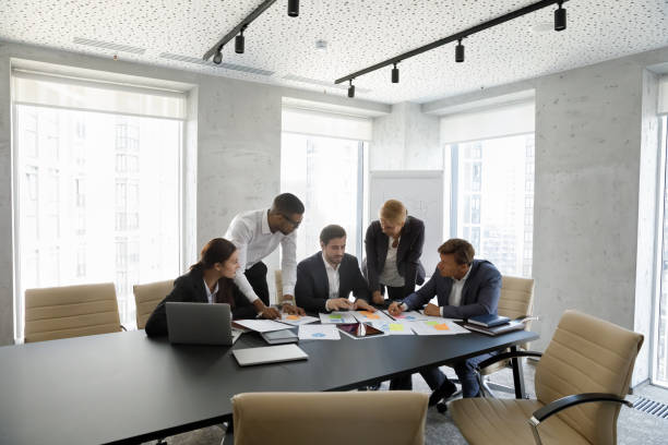 istock Concentrated successful happy diverse colleagues analyzing financial paper documents. 1418194807