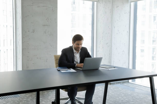 istock Focused young Caucasian businessman working on computer. 1418194839
