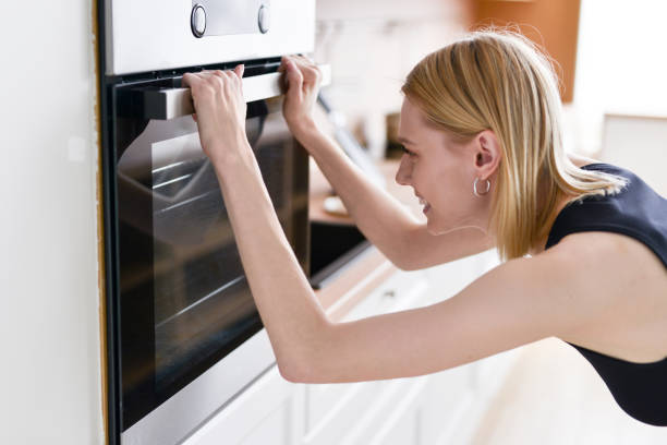 istock Woman peeks into oven while she is cooking 1418196003