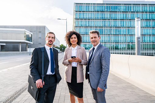 Multiracial group of business people bonding outdoors - International business corporate team wearing elegant suit meeting in a business park