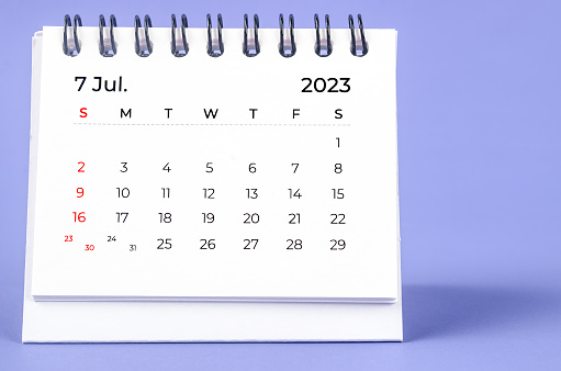El calendario mensual de escritorio de julio de 2023 para el año 2023 sobre fondo púrpura. photo
