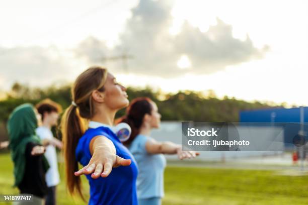 Mixed race woman exercising in park with friends